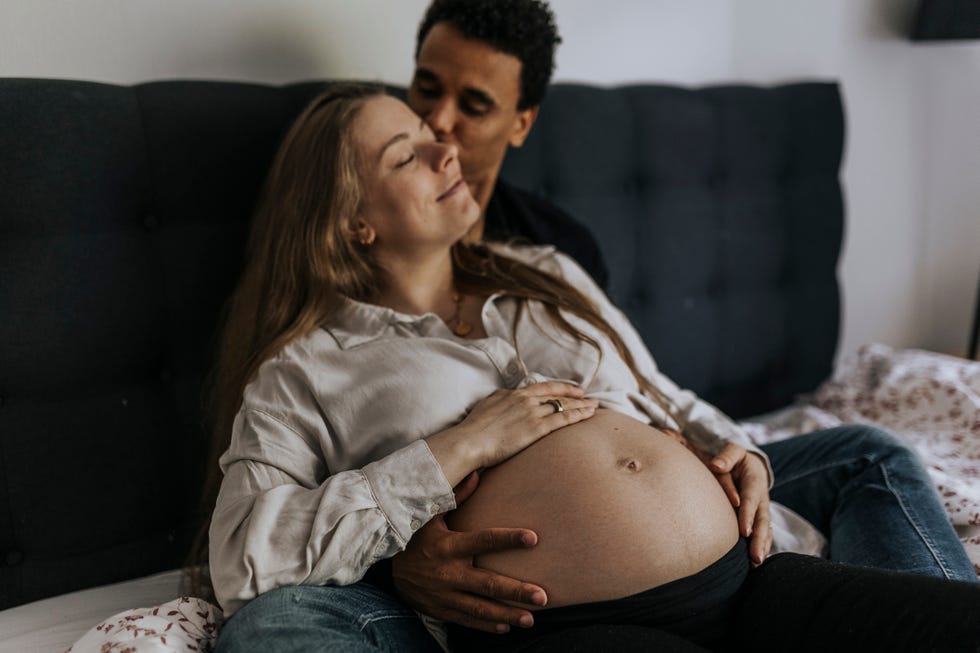 pregnant woman with partner sitting in bed